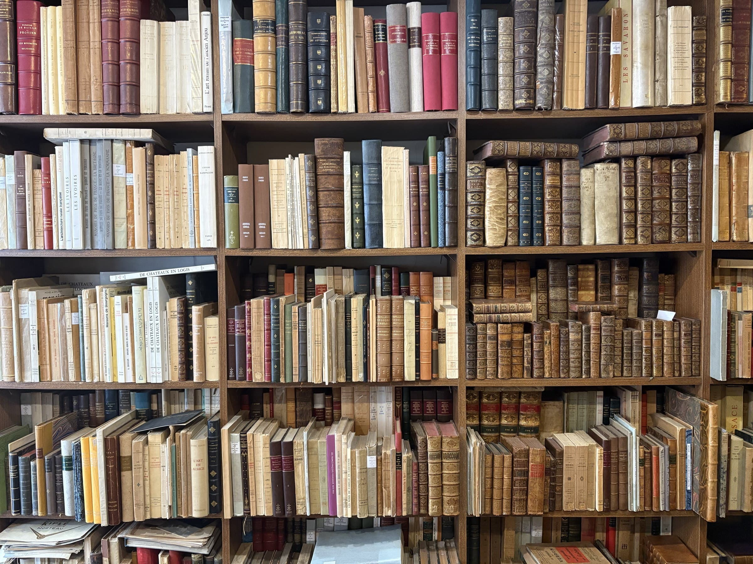 Rayonnages de la Librairie Valleriaux emplis de livres anciens de régionalisme en reliures de cuir, à Paris